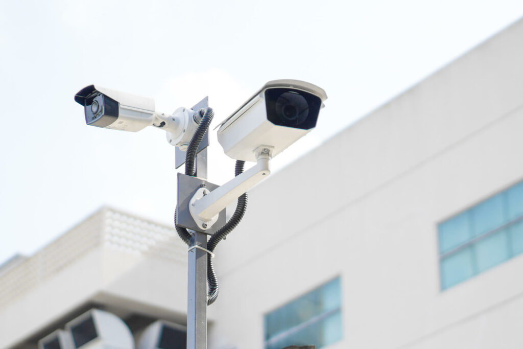 For your peace of mind, two CCTV cameras are installed on a metal pole outside a modern Merseyside building, helping to monitor and protect secure storage areas for customer safety.